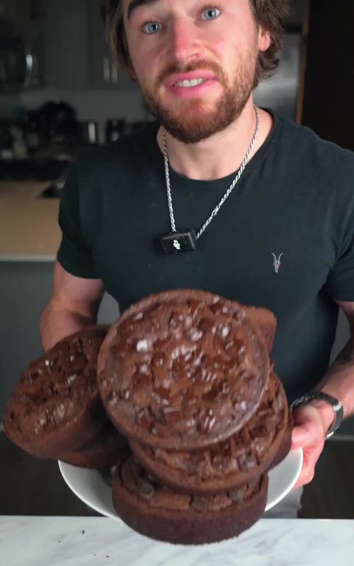(👇recipe) 83 Calorie Protein Crackly Top Fudge Brownie 👉Click link in bio to finally get lean without restrictions 😡Are you FOLLOWING @nickkazfit ✳️ Macros per serving (1/6 of massive circle brownie): 83 Cals, 5g Net Carbs, 2.5g Fat, 8.25g Protein Recipe makes 2 massive circle brownies shown in video. Note: If you bake these in a standard rectangular pan and cut into 12 brownies, you’ll get the same macros per serving.  Whole recipe total: ~99g protein. ✳️ Wet Ingredients: 2 Medium Eggs 120g (½ Cup) Egg Whites 170g (¾ Cup) 0% Greek Yogurt 30g (2 tbsp) Coconut Oil, melted 5mL (1 tsp) Vanilla Extract (optional) ✳️ Dry Ingredients: 210–230g (1 to 1⅛ Cups) Granulated 1:1 Sugar Substitute (ie: Lakanto or Swerve) or Regular Sugar 40g (⅓ Cup) All-Purpose Flour 50g (½ Cup + 2 tbsp) Cocoa Powder 60g (about 2 Scoop) Chocolate or Vanilla Protein Powder 3–4g (¾ tsp) Baking Powder Pinch of Salt ✳️ Mix-ins and Toppings (*optional*) Chocolate Chips or Chunks to Taste 👉 Everything that is optional is not included in da macros ✳️ Directions 1. Preheat oven to 350°F (175°C). 2. In a bowl, whisk together all wet ingredients. 3. Add dry ingredients and mix until smooth. 4. Pour into a 2 small circular springboard pans or one regular brownie tray. 5. Bake for 20–25 minutes (take out slightly underdone). Then enjoy!