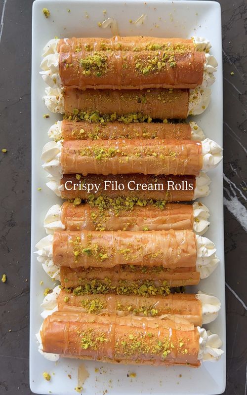 The crunch is INSANE. 🤯 These crispy filo cream rolls come together so easily and somehow taste like you spent hours on them. Light, flaky, creamy, and finished with that rosewater syrup… my family is obsessed. Crispy Filo Cream Rolls (yields 12) Ingredients 4 sheets filo dough, thawed Oil spray (I used avocado oil) Simple syrup 1/2 cup sugar 1/2 cup water 1 tbsp rosewater Cream filling 1 cup heavy whipping cream (dairy or non dairy) 1/3 cup instant vanilla pudding mix (powder only) Crushed pistachios, for topping Instructions Preheat oven to 350°F Lay out one sheet of filo dough, spray lightly with oil, and fold in half Cut to the length of your cannoli tubes and roll tightly around each tube You should get about 3 rolls per sheet Place on a parchment lined baking sheet and bake for about 20 minutes until golden Meanwhile, make the syrup by bringing sugar, water, and rosewater to a boil Reduce and simmer for about 7 minutes until slightly thickened For the filling, whip the cream with the pudding mix until thick and stable Transfer to a piping bag fitted with a tip Once the rolls are baked, let cool slightly and slide the tubes out Fill each roll from both ends with the cream Plate, drizzle with syrup, and finish with crushed pistachios Best enjoyed fresh, within a few hours.  #sivanskitchen #easy #dessert #shabbat #EasyRecipes 